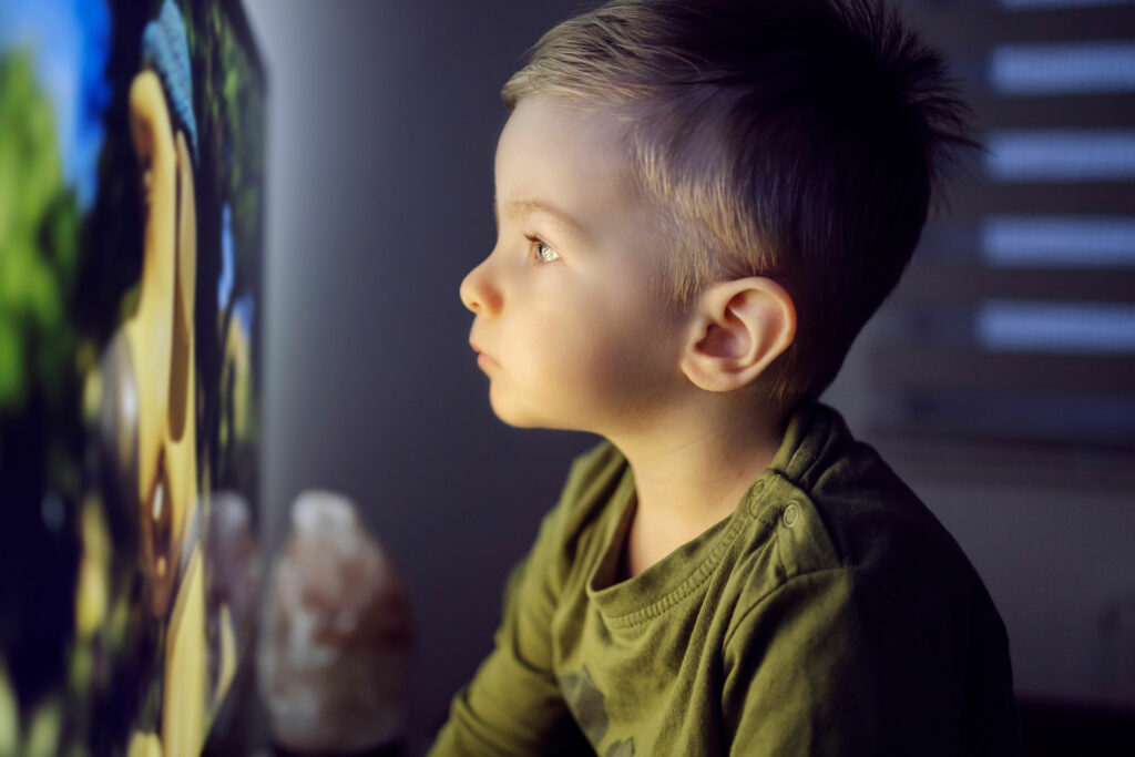 un enfant regardant la tele de trop près
