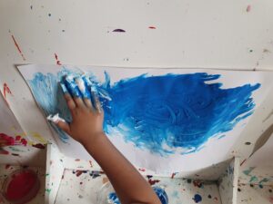 Un enfant est en train de peintre à l'aide de sa main