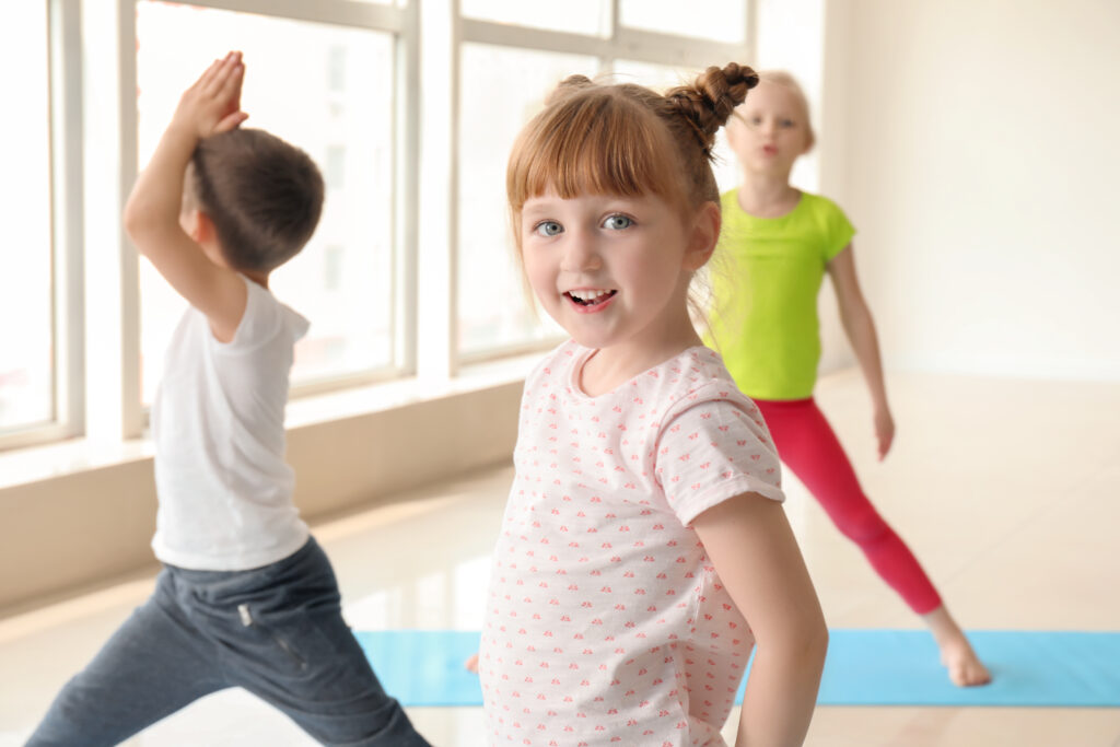 Trois enfants sont en train de faire de la danse ou de la gym