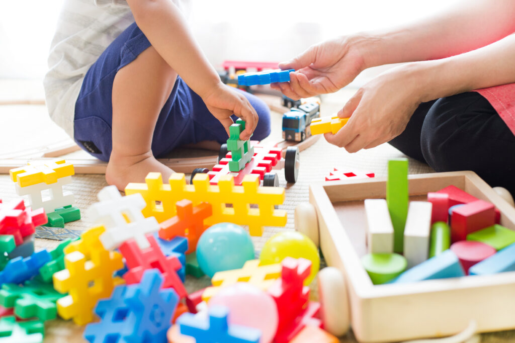 une femme est en train de jouer avec un enfant et des legos