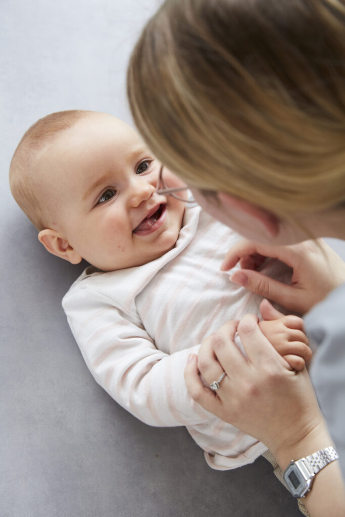 socialisation de l'enfant par le professionnelle qui fait un sourire à un bébé