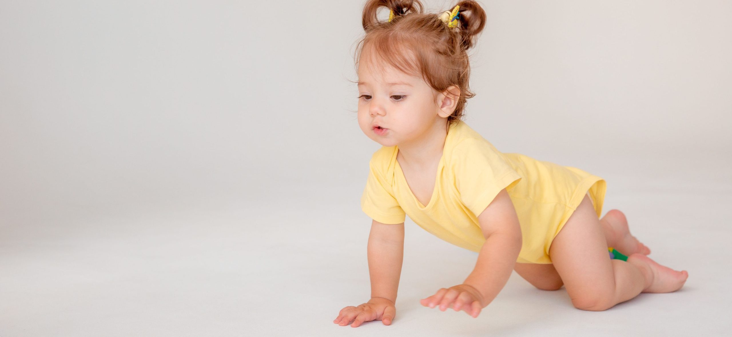 baby girl starting to walk crawling on a white background