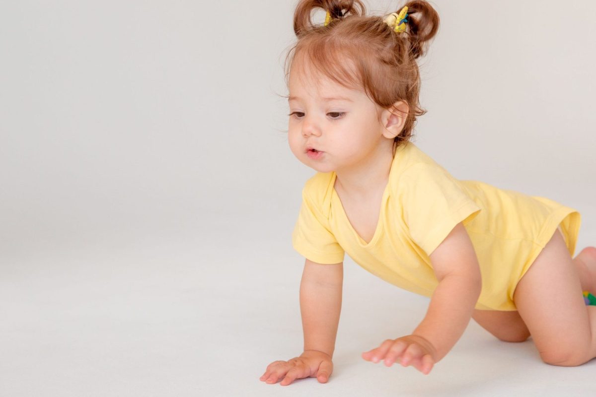 baby girl starting to walk crawling on a white background